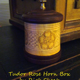 Tudor Rose Keepsake Box The Tudor Rose is the traditional floral heraldic emblem of England and is engraved in four places. This horn box is lathed turned. The base and top are American black walnut.
